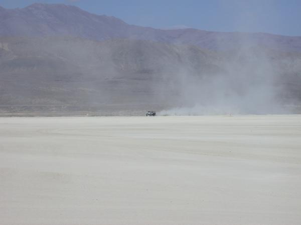 DPW truck dragging a chunk of fence around to flatten out the last of the playa